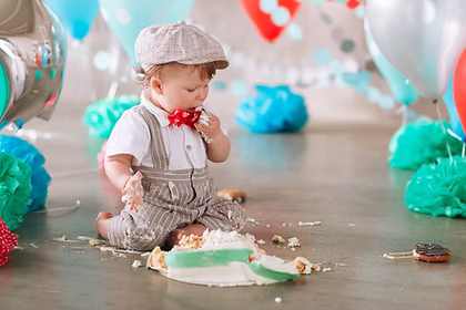 Baby boy touching his first birthday cake. Making messy cakesmash in decorated studio loca